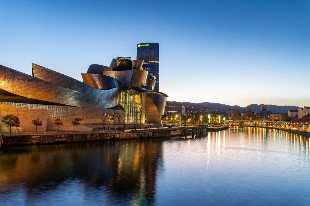 Stunning view of the Guggenheim Museum Bilbao reflecting in the Nervion River at dusk.